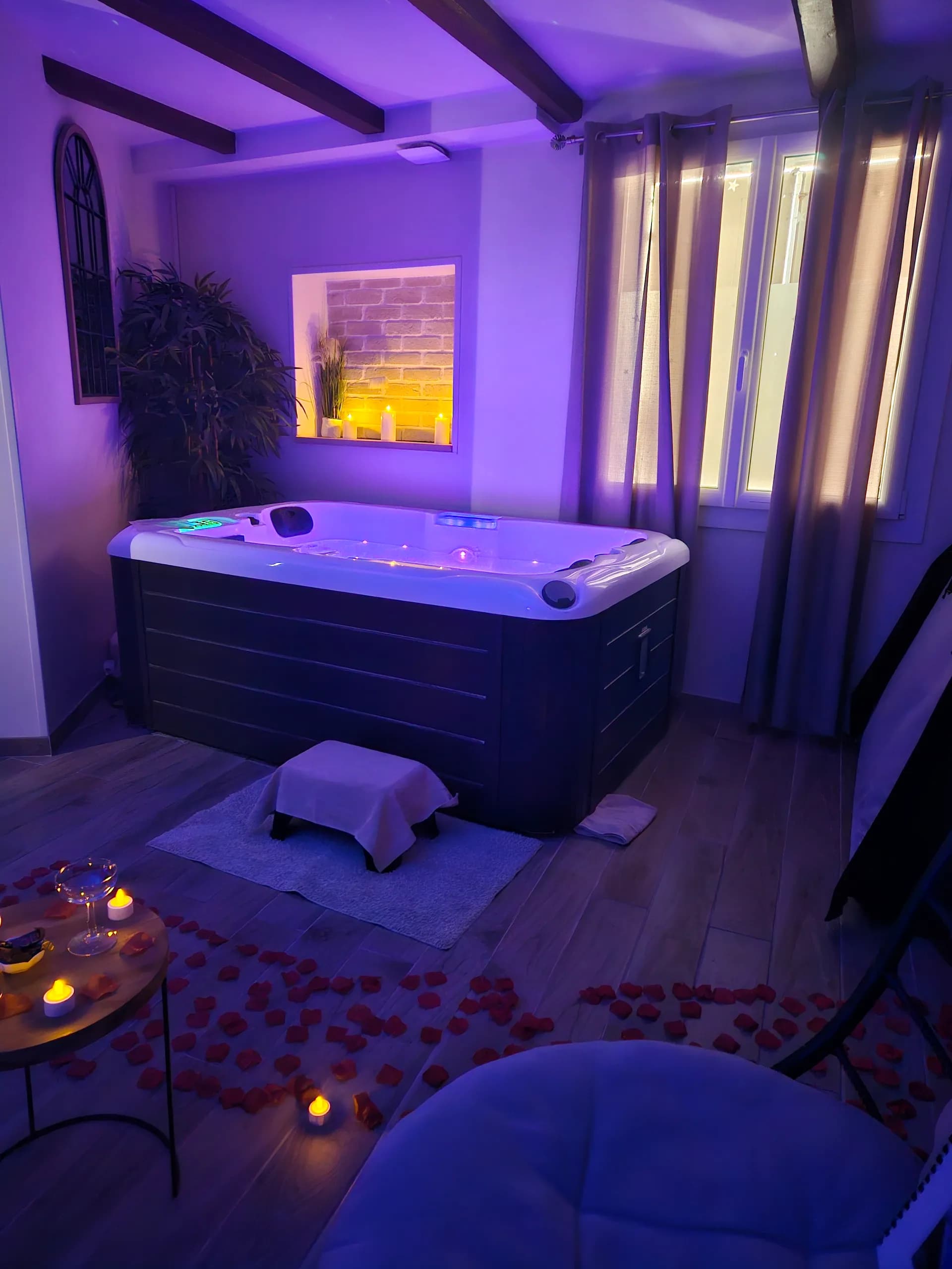 Spa privatif en luminothérapie violette avec pétales de roses
