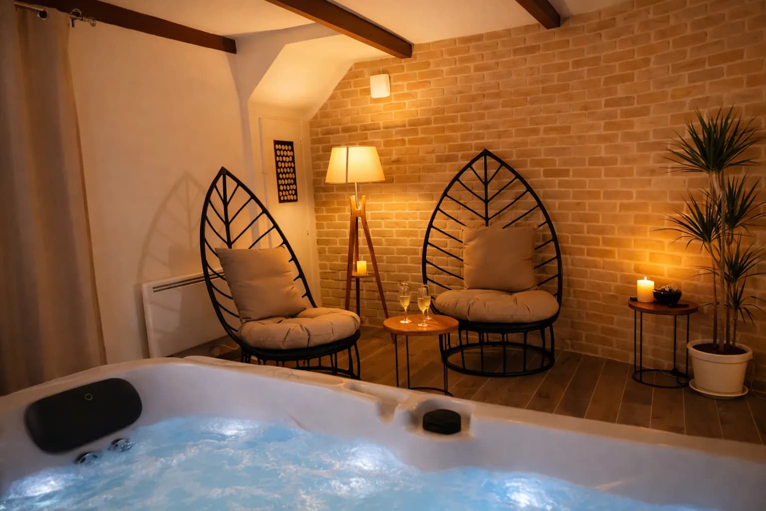 Spa privatif allumé et son coin détente avec deux fauteuils