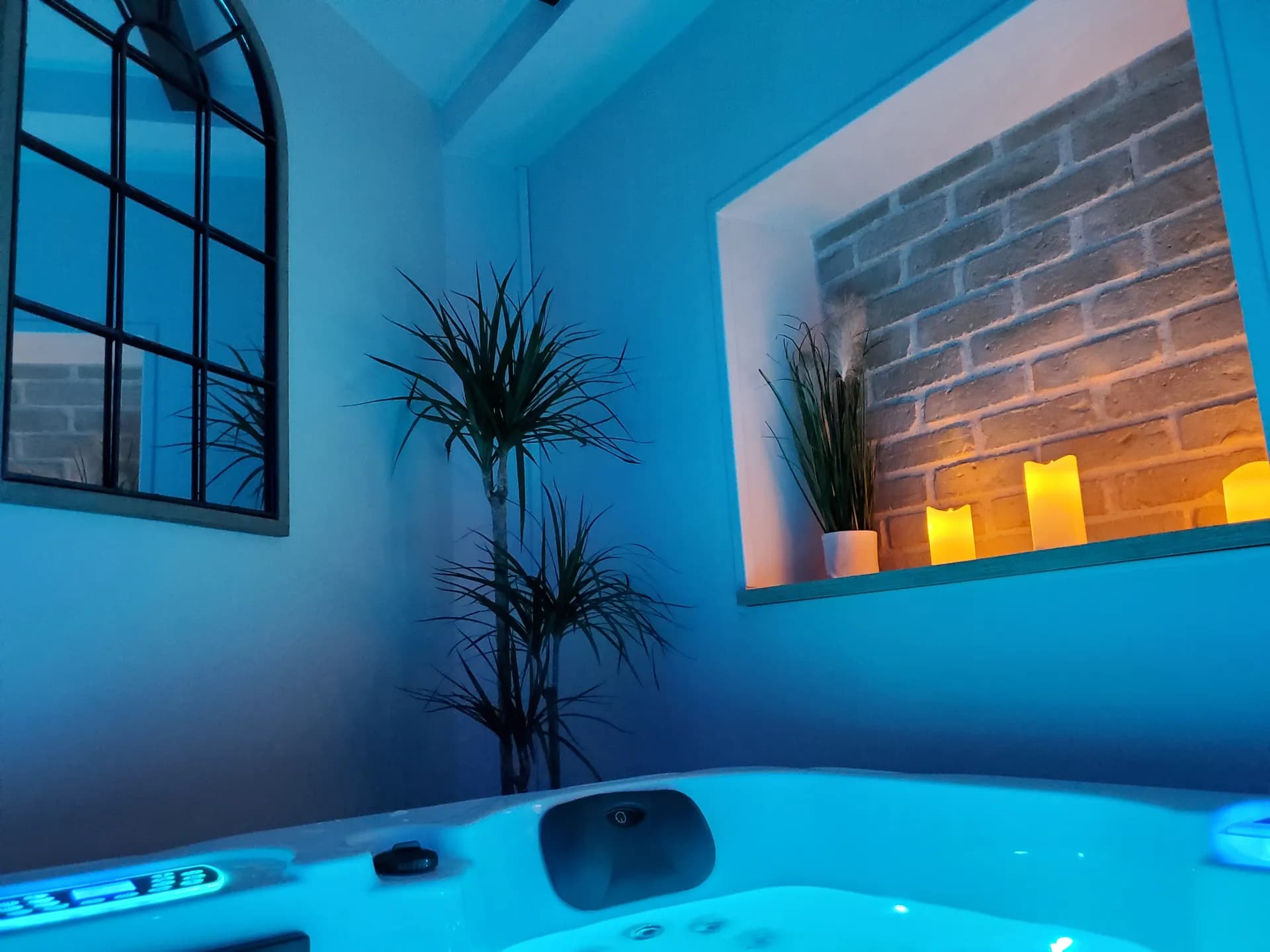 Spa privatif en luminothérapie bleue, éclairé aux bougies