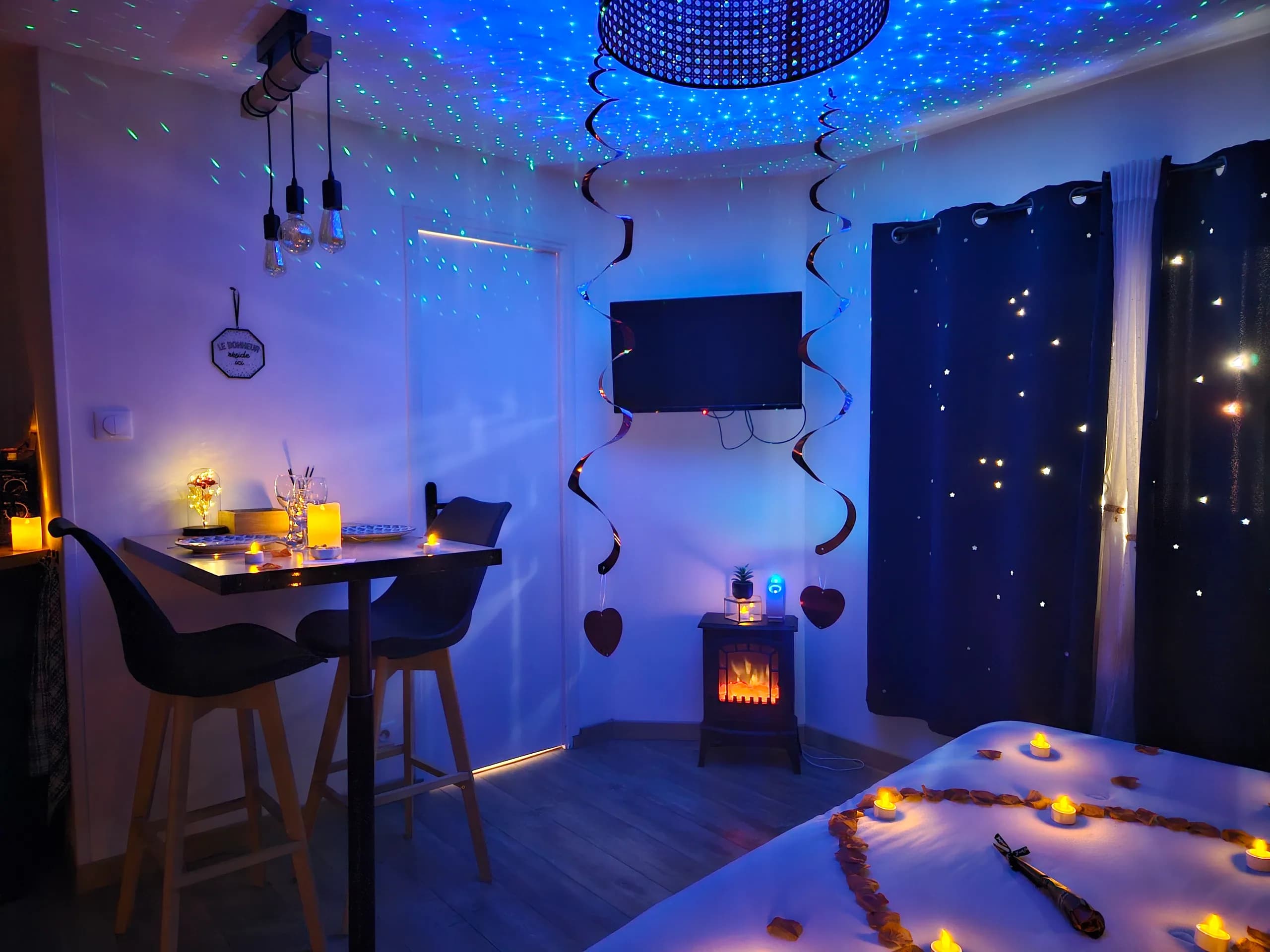 Chambre romantique sous un ciel étoilé, table dressée aux bougies